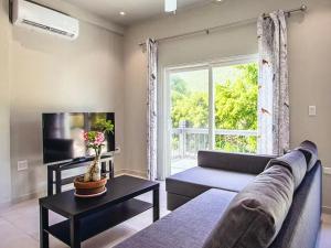 a living room with a couch and a large window at Seabreez Hideaway Escape in Dawn Beach
