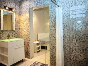 a bathroom with a shower with a sink and a bed at Seabreez Hideaway Escape in Dawn Beach