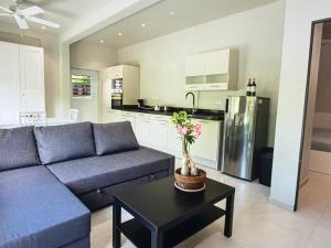 a living room with a blue couch and a kitchen at Seabreez Hideaway Escape in Dawn Beach +6 photos