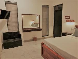 a bedroom with a bed and a mirror and a chair at Lisbon Lagoons in Negombo