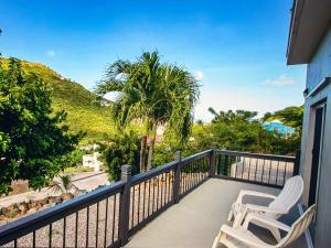 a balcony with two chairs and a view of the ocean at Seabreez Hideaway Escape in Dawn Beach