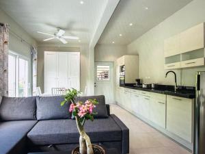 a living room with a couch and a kitchen at Seabreez Hideaway Escape in Dawn Beach