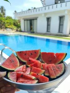 a bowl of watermelon slices on a table next to a pool at Lisbon Lagoons in Negombo