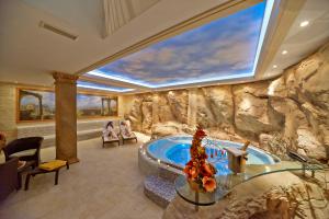 ein großes Badezimmer mit einer in eine Steinwand eingelassenen Badewanne in der Unterkunft Hotel Stefanik in Myjava