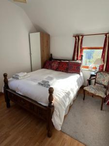 a bedroom with a bed and a chair and a window at Highfields Farm B&B in Stone