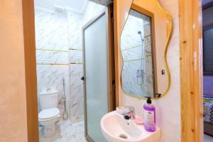 a bathroom with a sink and a shower with a mirror at Riad Bollywood-Royal Stay C in Benguerir +7 photos
