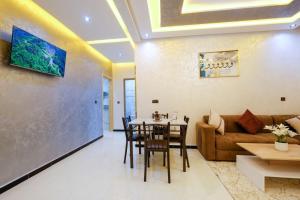 a living room with a table and a couch at Riad Bollywood-Royal Stay C in Benguerir