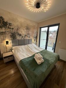 a bedroom with a bed with two towels on it at Belle View Strumyk 212 - Mountain View & SPA in Szklarska Poręba