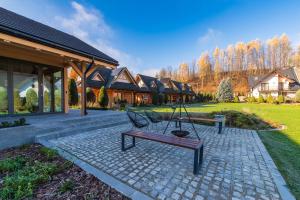 a patio with two benches and a house at Domki Trzy Korony in Sromowce Niżne