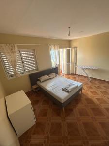 a bedroom with a bed and a wooden floor at Home Lenda in Tarrafal