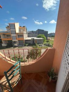 a balcony with a chair and a view of a city at Home Lenda in Tarrafal