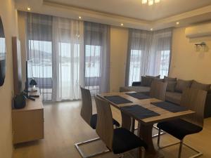 a dining room and living room with a table and a couch at Orchidea Apartmanház Egerszalók in Egerszalók