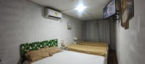 a small room with two beds and a tv at Verde limón in Olavarría