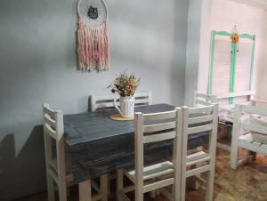 a dining room table with chairs and a clock on the wall at Verde limón in Olavarría