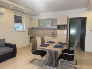 a kitchen and living room with a table and chairs at Orchidea Apartmanház Egerszalók in Egerszalók