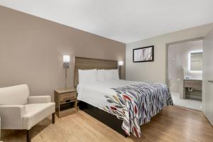 ein Hotelzimmer mit einem Bett und einem Stuhl in der Unterkunft Red Roof Inn Georgetown, KY in Georgetown