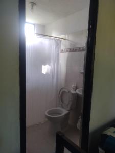 a bathroom with a toilet with a shower curtain at Mágica Cabaña familiar cerca al mar in Coveñas +25 photos