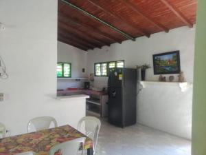 a kitchen with a refrigerator and a table with chairs at Mágica Cabaña familiar cerca al mar in Coveñas