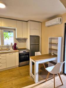 a kitchen with white cabinets and a table and chairs at Villa Vadian & Pool in Gevgelija