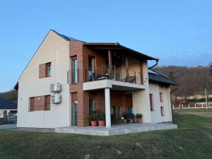 a house with a balcony on the side of it at Orchidea Apartmanház Egerszalók in Egerszalók