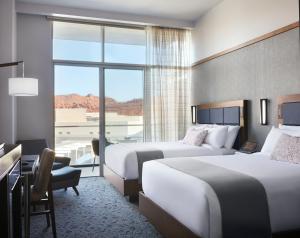 a hotel room with two beds and a desk at Black Desert Resort in Ivins