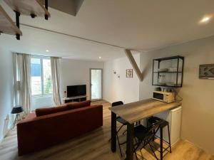 a living room with a couch and a table at Gîte De la Cour au Grenier 2 in Chauvigny