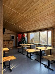 a group of tables in a room with wooden ceilings at Arrow Burabay in Borovoye