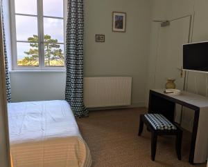 a bedroom with a bed and a desk and a window at Le Château de La Pomarède in La Pomarède