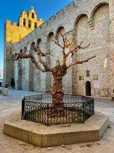 a statue of a tree in front of a building at Un cocon en Camargue in Saintes-Maries-de-la-Mer