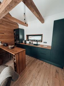 a kitchen with green cabinets and a wooden table at Cozy Chalet in Smolné Pece