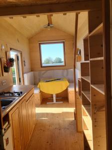 a small kitchen with a yellow chair in a tiny house at maison du bonheur in Tréflez