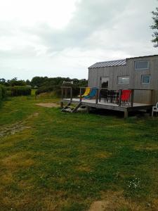 a trailer with a deck and a table and chairs at maison du bonheur in Tréflez