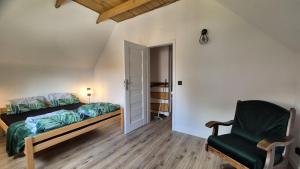 a bedroom with a bed and a chair at Chatki ŁoRawa w Jabłonce in Jabłonka +22 photos