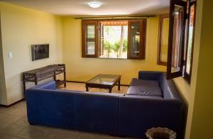 a living room with a blue couch and a table at Aqua Villa by Garvetur in Beberibe
