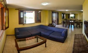 a living room with a blue couch and a table at Aqua Villa by Garvetur in Beberibe