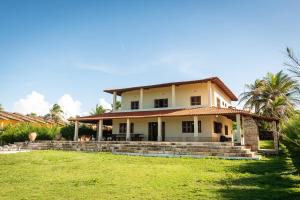 a house on a hill with a grass yard at Aqua Villa by Garvetur in Beberibe