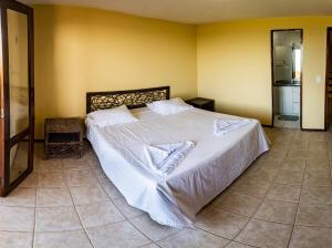 a bedroom with a large bed with white sheets at Aqua Villa by Garvetur in Beberibe +45 photos