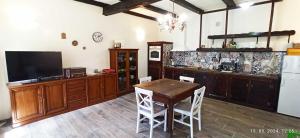 a kitchen with a table and a tv and a refrigerator at Domaći Berek in Hlebine