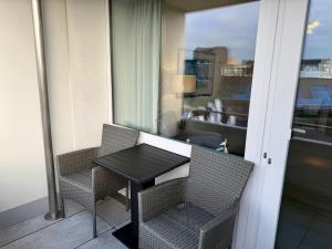 a table and chairs on a balcony with a window at Wiking, App 201A in Westerland