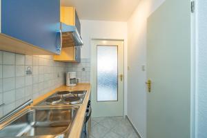 a kitchen with a stove and a sink at Wiking, App 201A in Westerland +18 photos