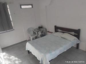 a bedroom with a bed and a table with a chair at Nelson Pinheiro in São Luís