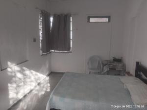 a white room with a bed and a window at Nelson Pinheiro in São Luís