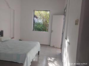 a white room with a bed and a window at Nelson Pinheiro in São Luís