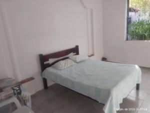 a bedroom with a bed in a room with a window at Nelson Pinheiro in São Luís