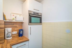 a kitchen with a refrigerator and a microwave at Sylter Residenz, App 56 in Westerland