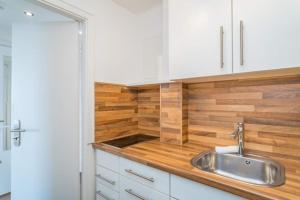 a kitchen with a sink and a wooden wall at Sylter Residenz, App 56 in Westerland