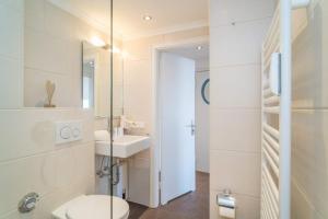 a bathroom with a toilet and a sink at Sylter Residenz, App 56 in Westerland +13 photos