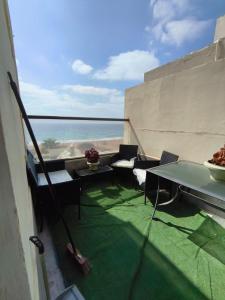 a balcony with a table and chairs and the ocean at על הים in Nahariyya