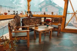 a table and two chairs on a porch with a table at Casuta Cerbului Colibita in Colibiţa