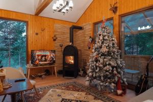 a christmas tree in a living room with a fireplace at Casuta Cerbului Colibita in Colibiţa